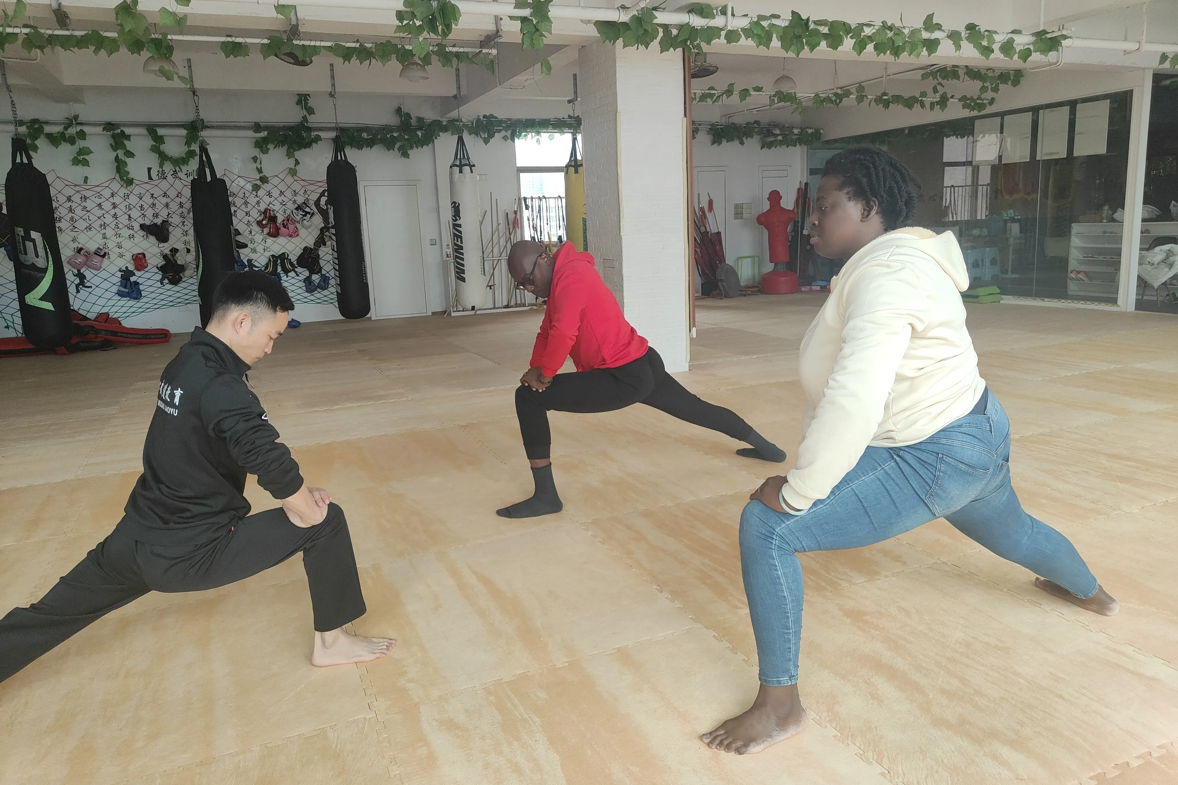 Students practicing Chinese kung fu advanced techniques and sparring exercises, showing their progress in martial arts training with professional coaching and equipment, demonstrating the evolution from basic stances to combat skills.